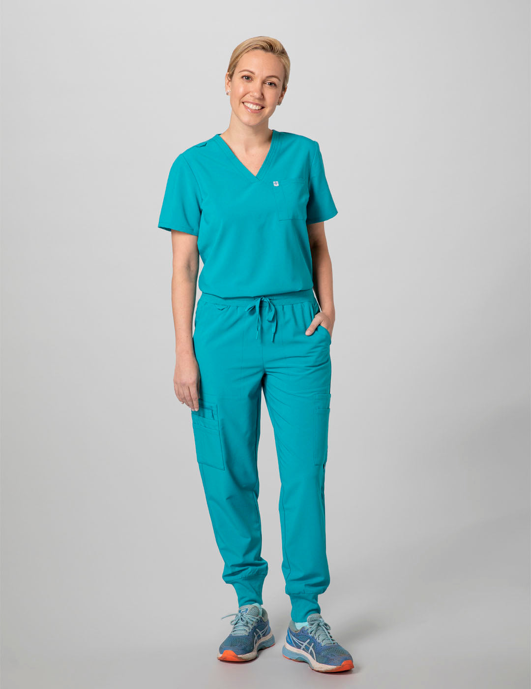 Women's scrub top in teal, featuring a classic V-neck style and two practical pockets