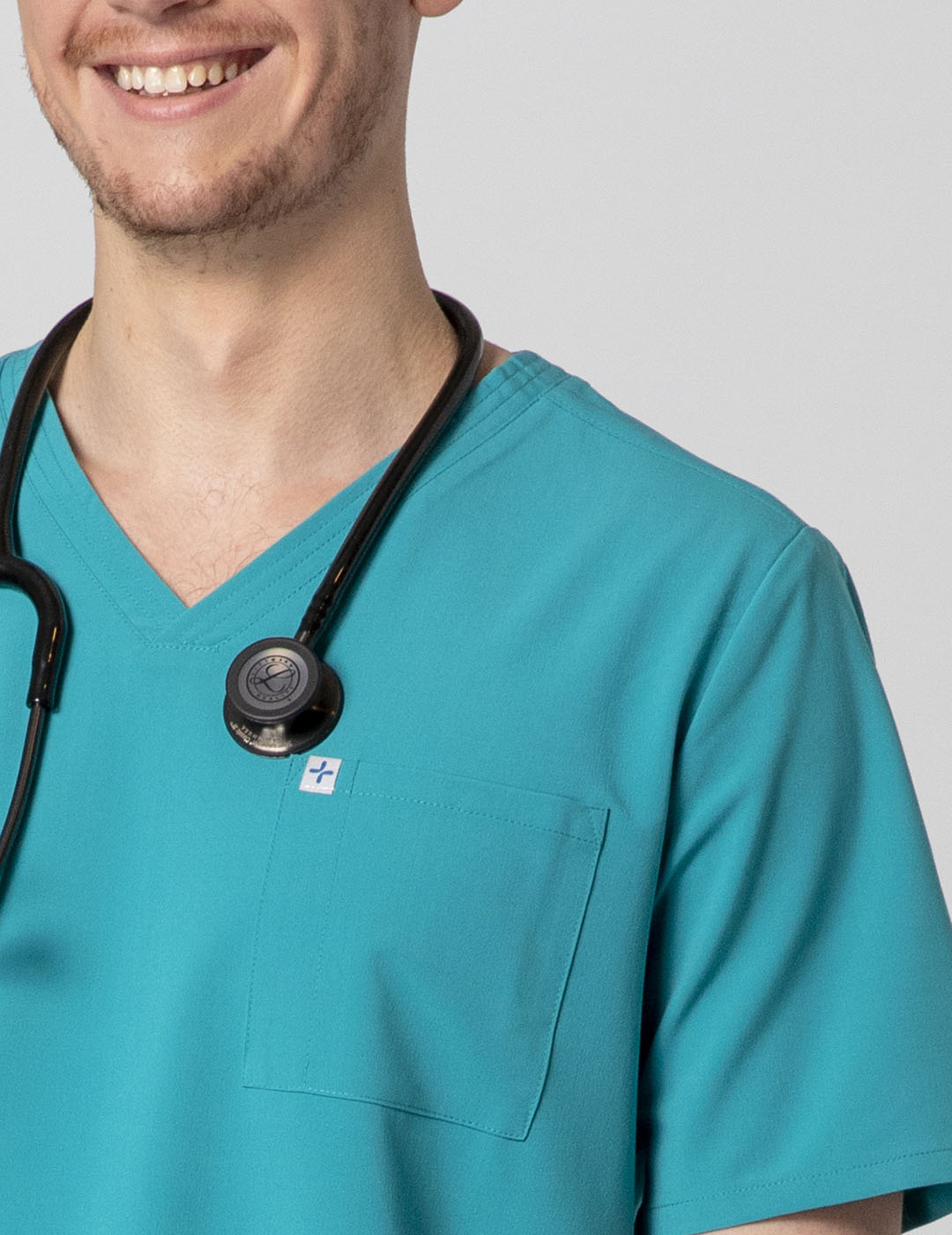 Men's scrub top in teal, featuring a V-neck design and two practical pockets for utility