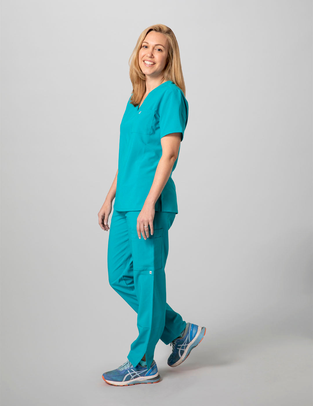 Comfortable women&#39;s scrub pants in teal, crafted with nine pockets for added practicality