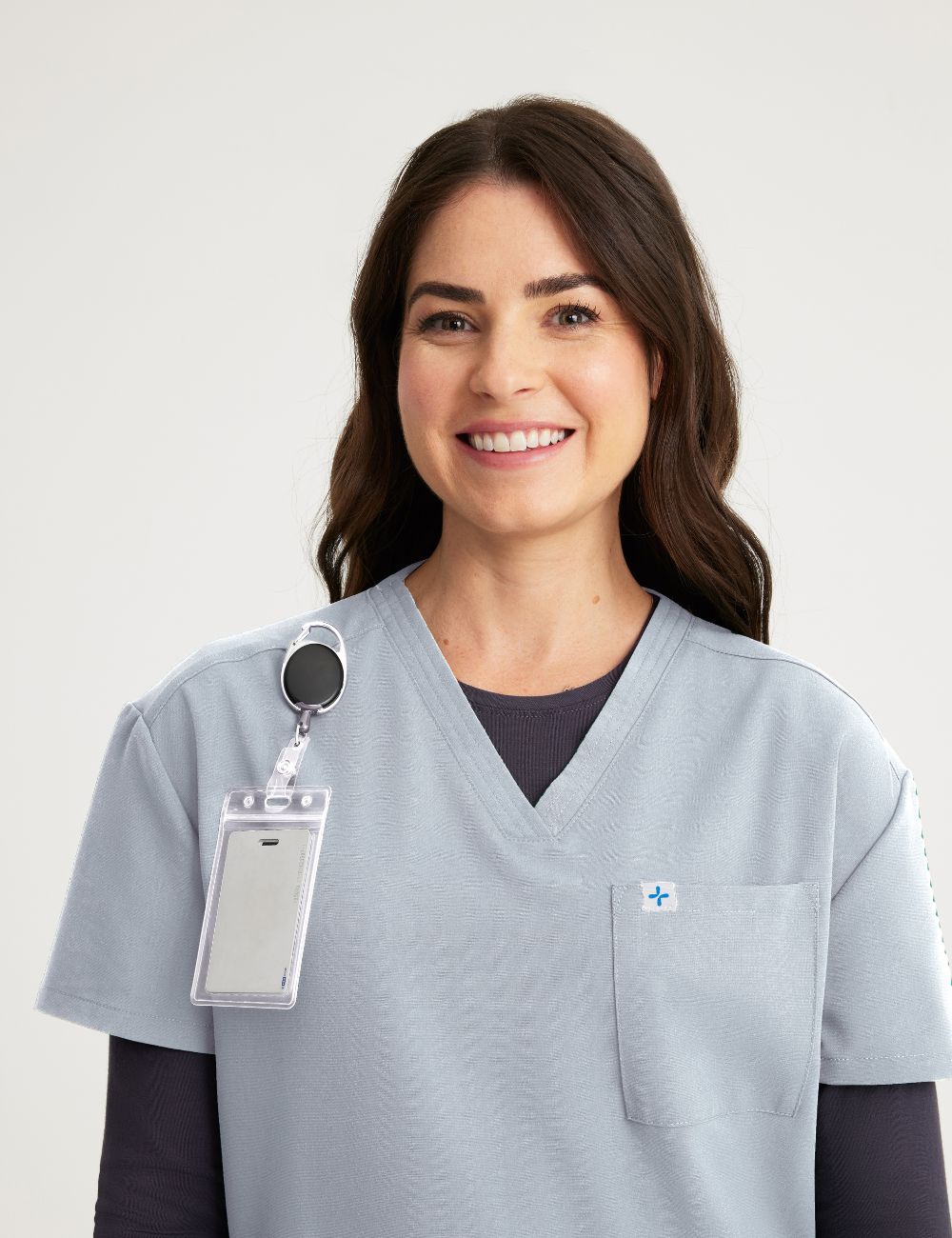 Women's scrub top in stone gray, featuring a sleek V-neck style and two functional pockets