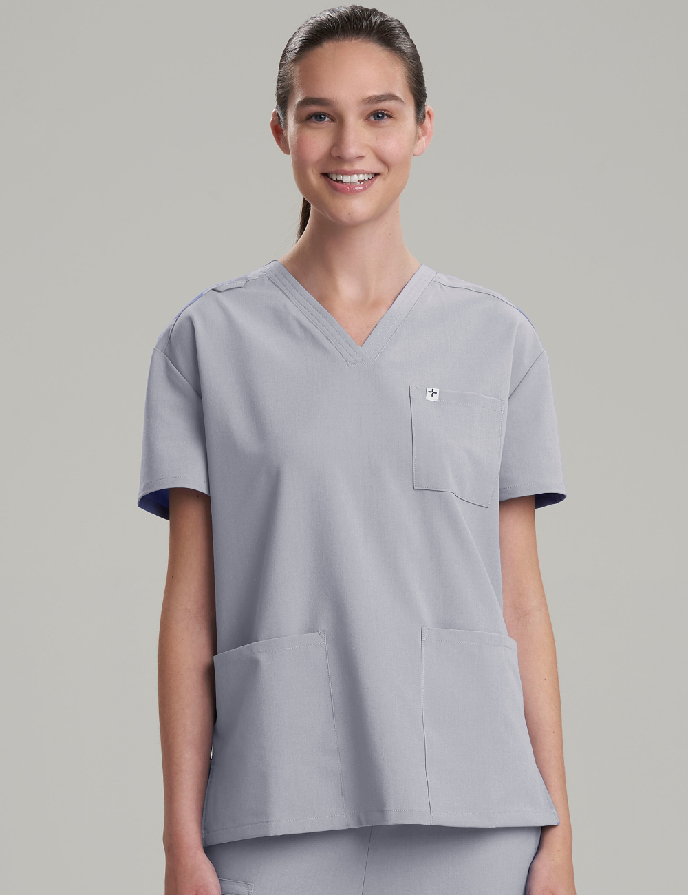 Stone gray women's V-neck scrub top with three pockets, designed for professional and practical use