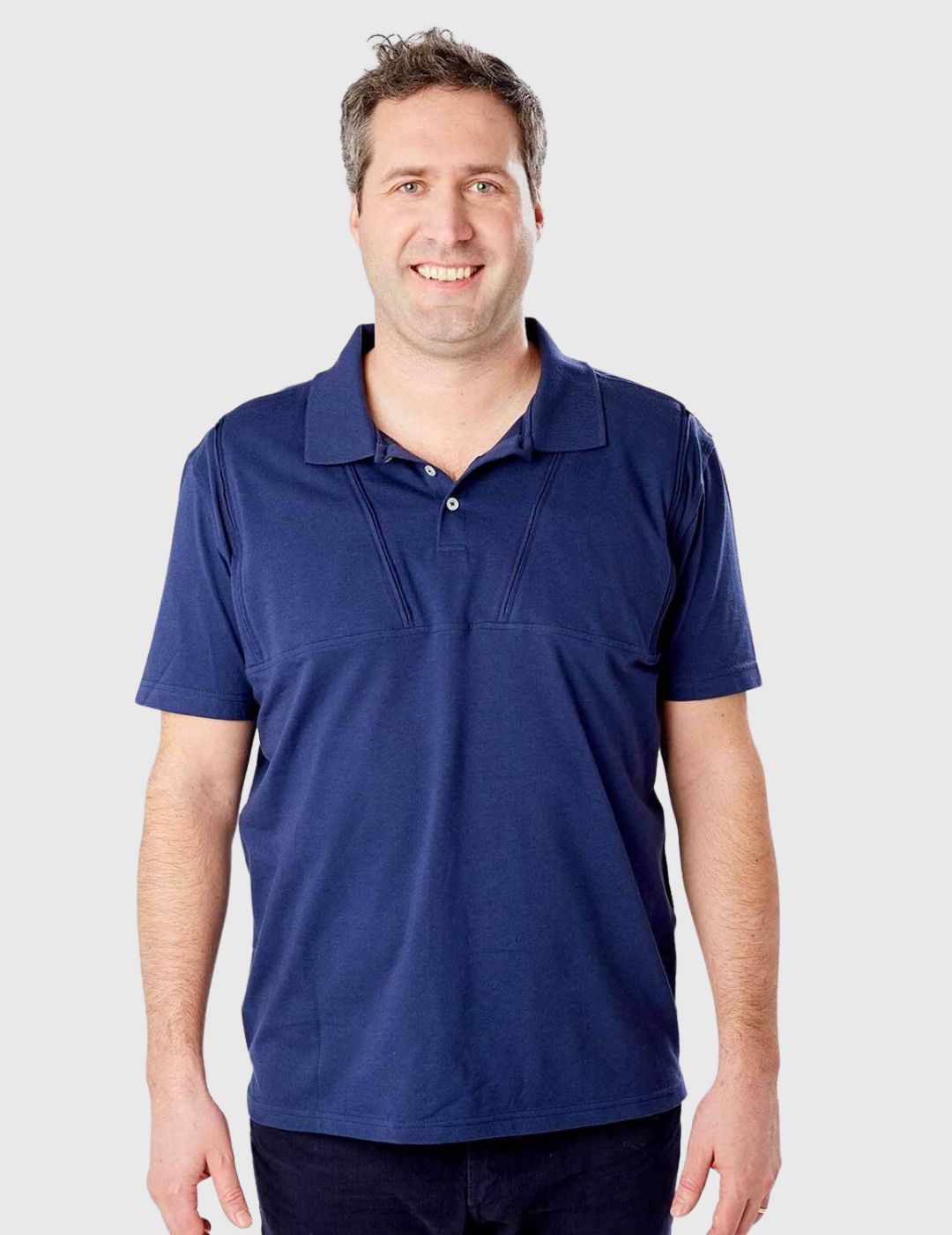 Navy blue polo featuring dual chest port access by Care+Wear, blending style with functionality. Model is wearing a size Large