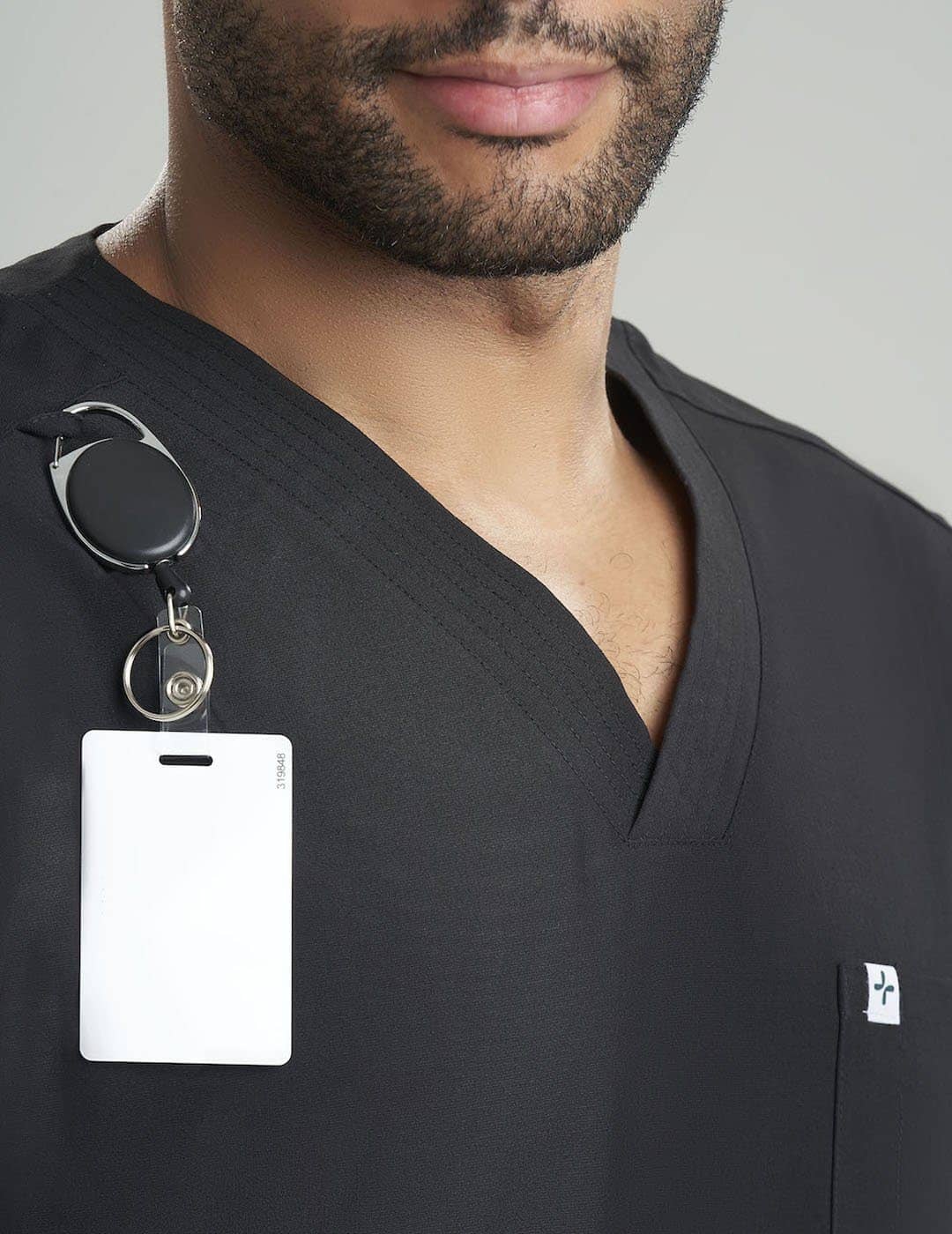 Classic Black Men's 7-Pocket V-Neck Scrub Top by Care+Wear, designed for durability, functionality, and a professional style. Model is wearing size Large