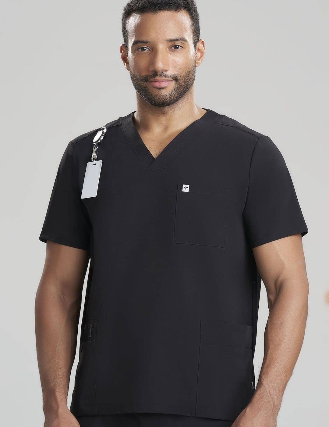 Classic Black Men's 7-Pocket V-Neck Scrub Top by Care+Wear, designed for durability, functionality, and a professional style. Model is wearing size Large