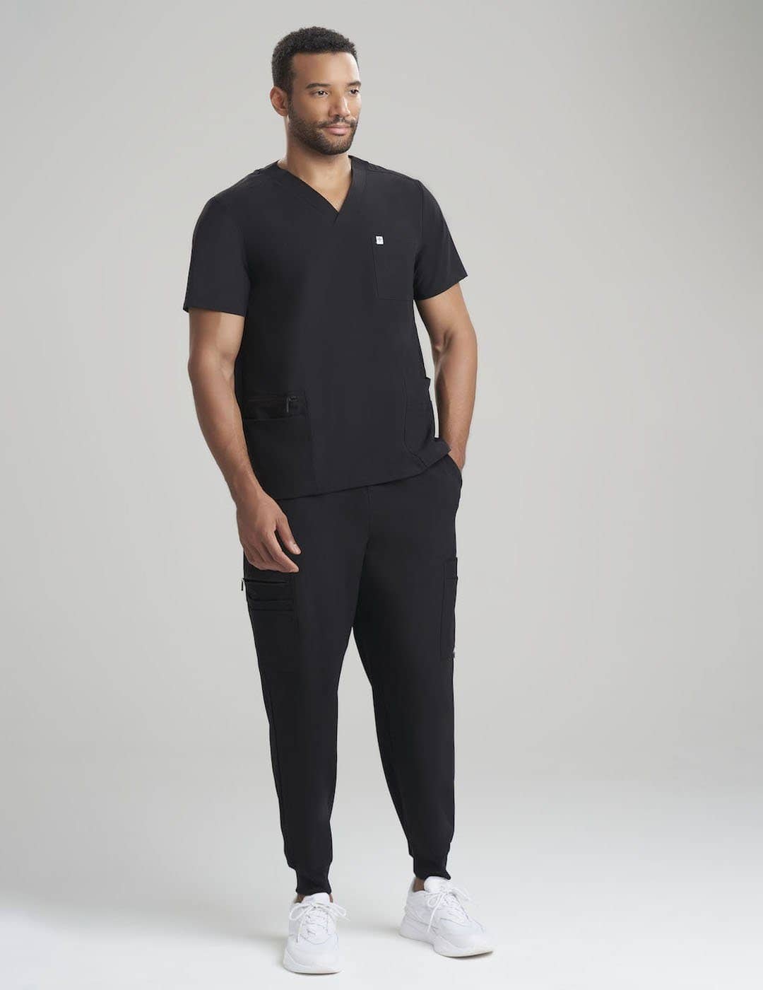 Men's scrub top in black, featuring a modern V-neck style and ample pocket storage