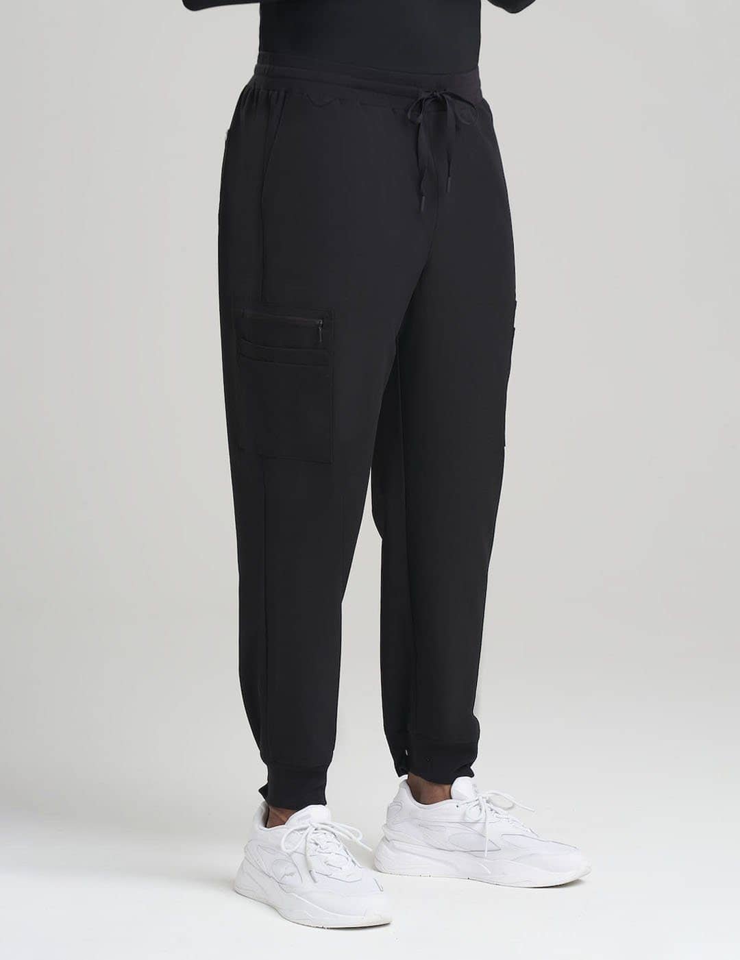 Classic Black Men's 10-Pocket Jogger Scrub Pants from Care+Wear, designed for durability, style, and abundant storage options. Model is wearing size Large