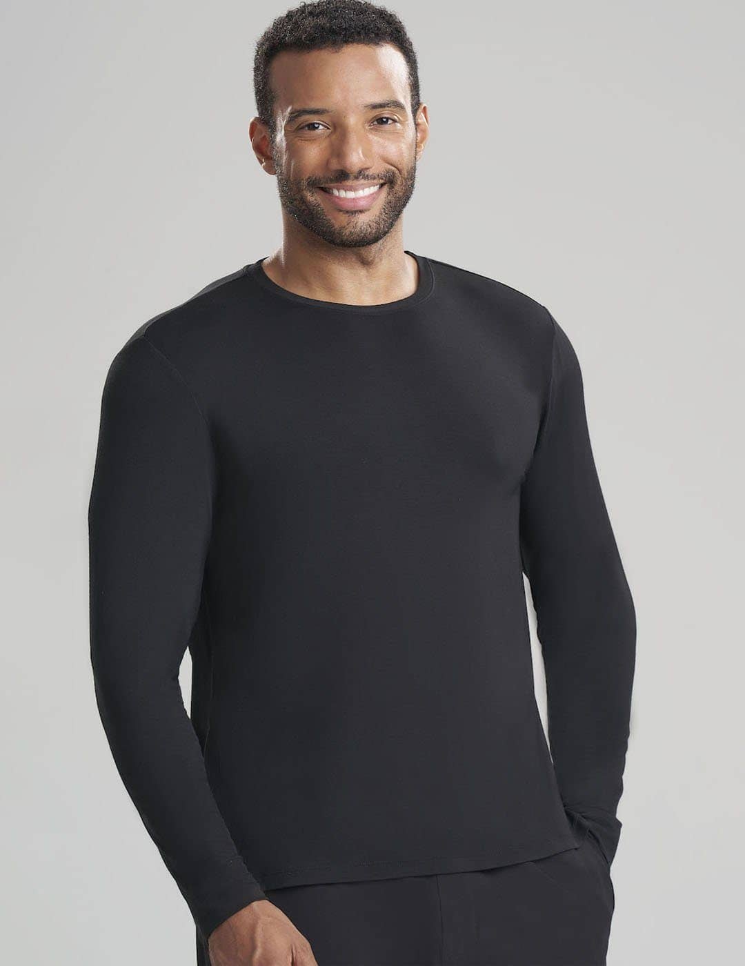 Care+Wear Men's Long Sleeve Underscrub Shirt in Black, offering a smooth, durable layer for extended clinical wear. Model is wearing size Large
