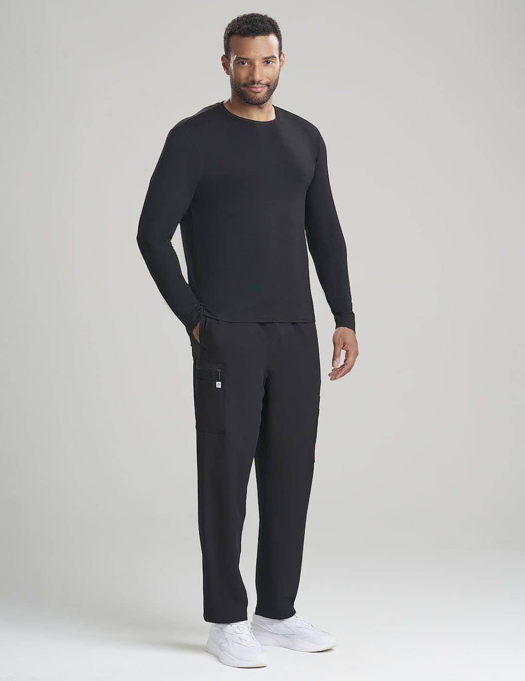 Care+Wear Men's Long Sleeve Underscrub Shirt in Black, offering a smooth, durable layer for extended clinical wear. Model is wearing size Large
