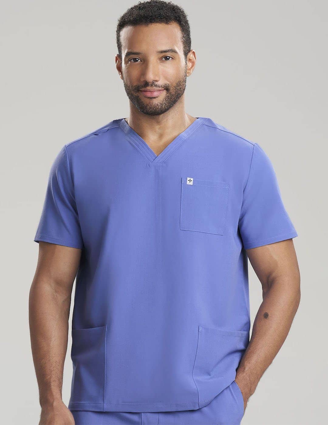 Care+Wear Men's 3-Pocket V-Neck Scrub Top in Ceil, offering a lighter shade with practical pocket design for healthcare work. Model is wearing size Large