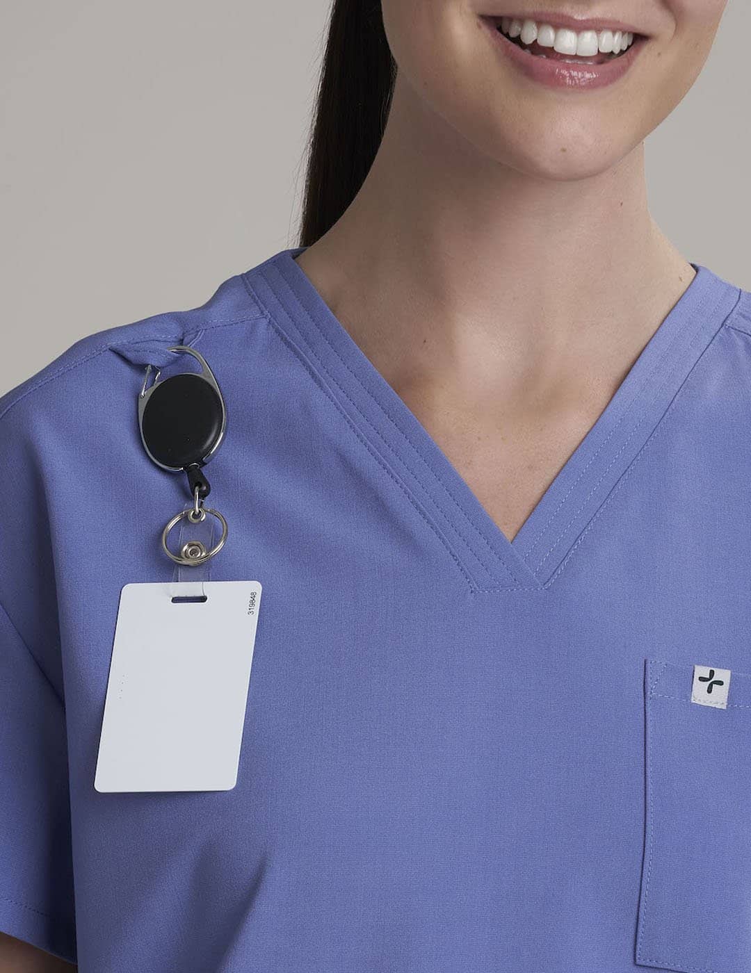 Care+Wear Women's 3-Pocket V-Neck Scrub Top in Ceil, providing a light, airy color with practical design for clinical work. Model is wearing size X-Small