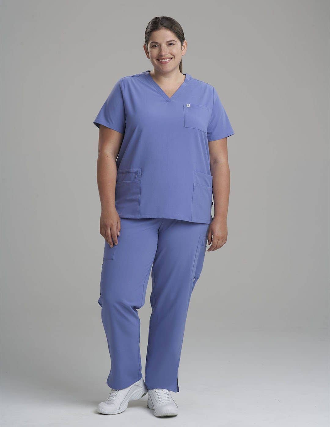Comfortable ceil women's V-neck scrub top with six pockets, ideal for long shifts in healthcare. Model is wearing size Large