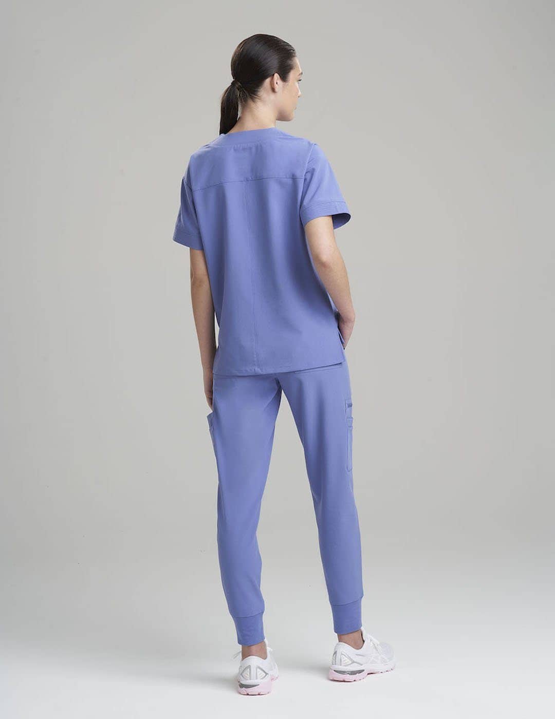 Stylish women's scrub top in ceil, combining a sleek V-neck design with eight spacious pockets.