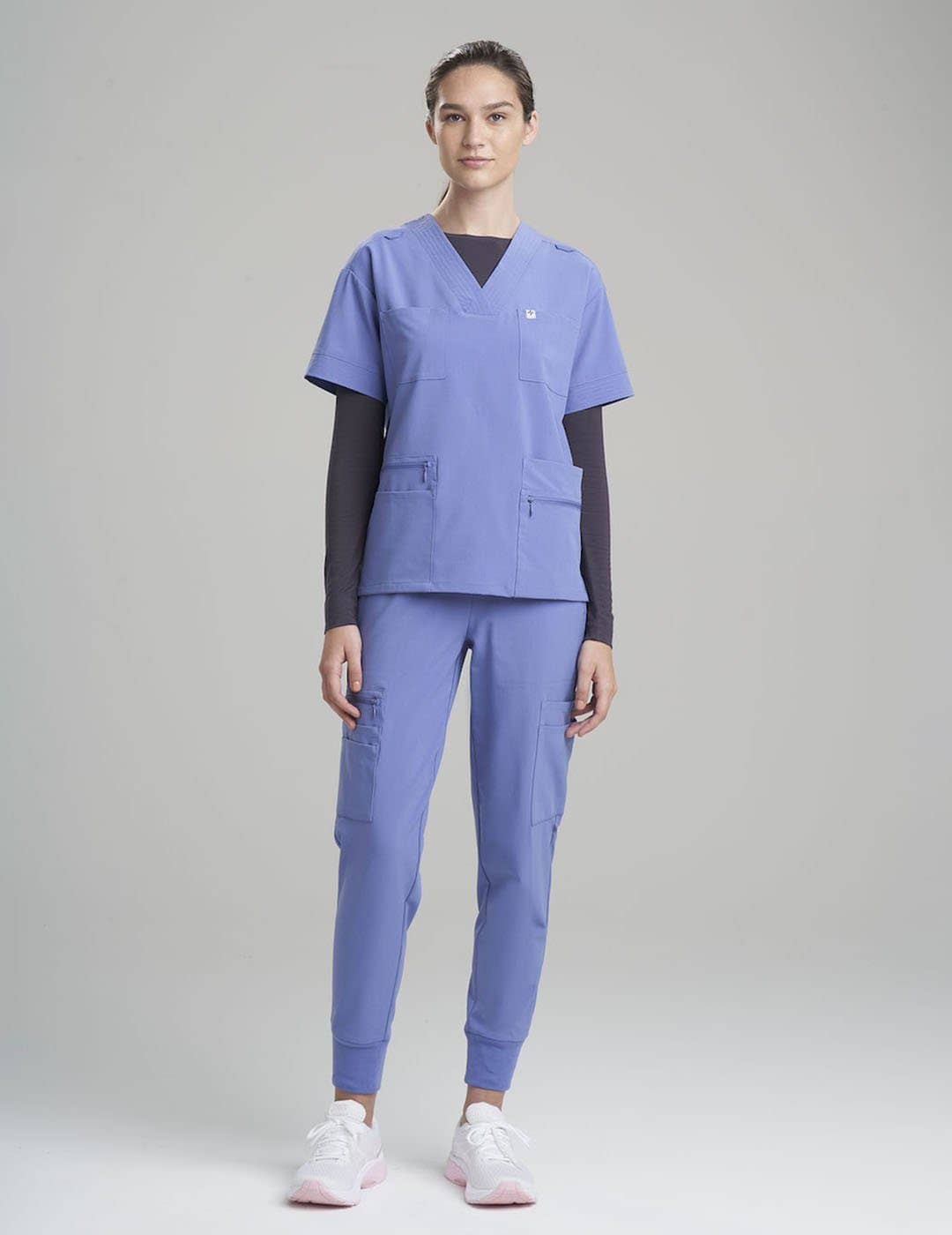 Versatile ceil scrub top for women, featuring a modern V-neck and eight pockets for daily use.