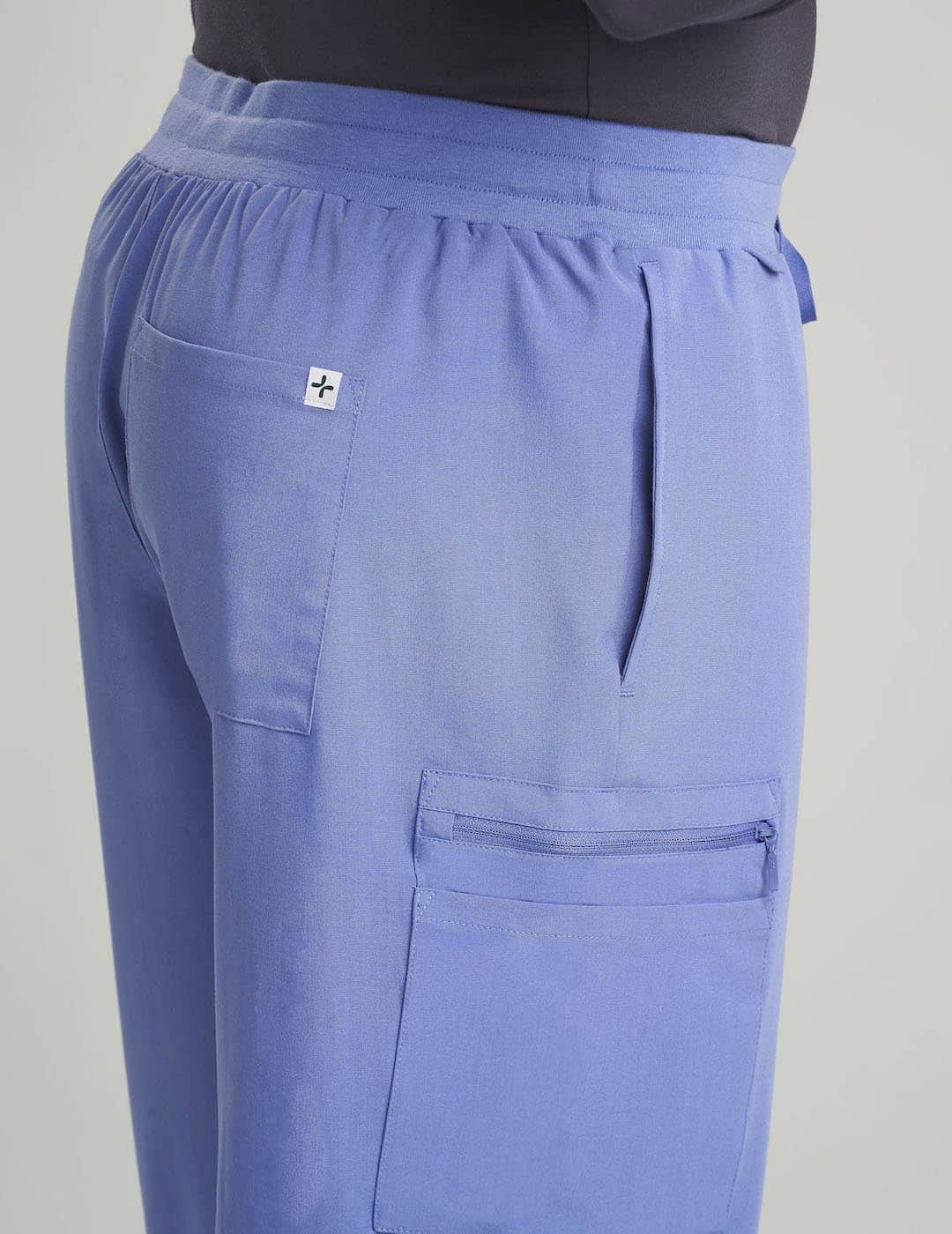 Ceil Men's 7-Pocket Straight Leg Scrub Pants by Care+Wear, combining a light shade with practical design for medical professionals. Model is wearing size Large