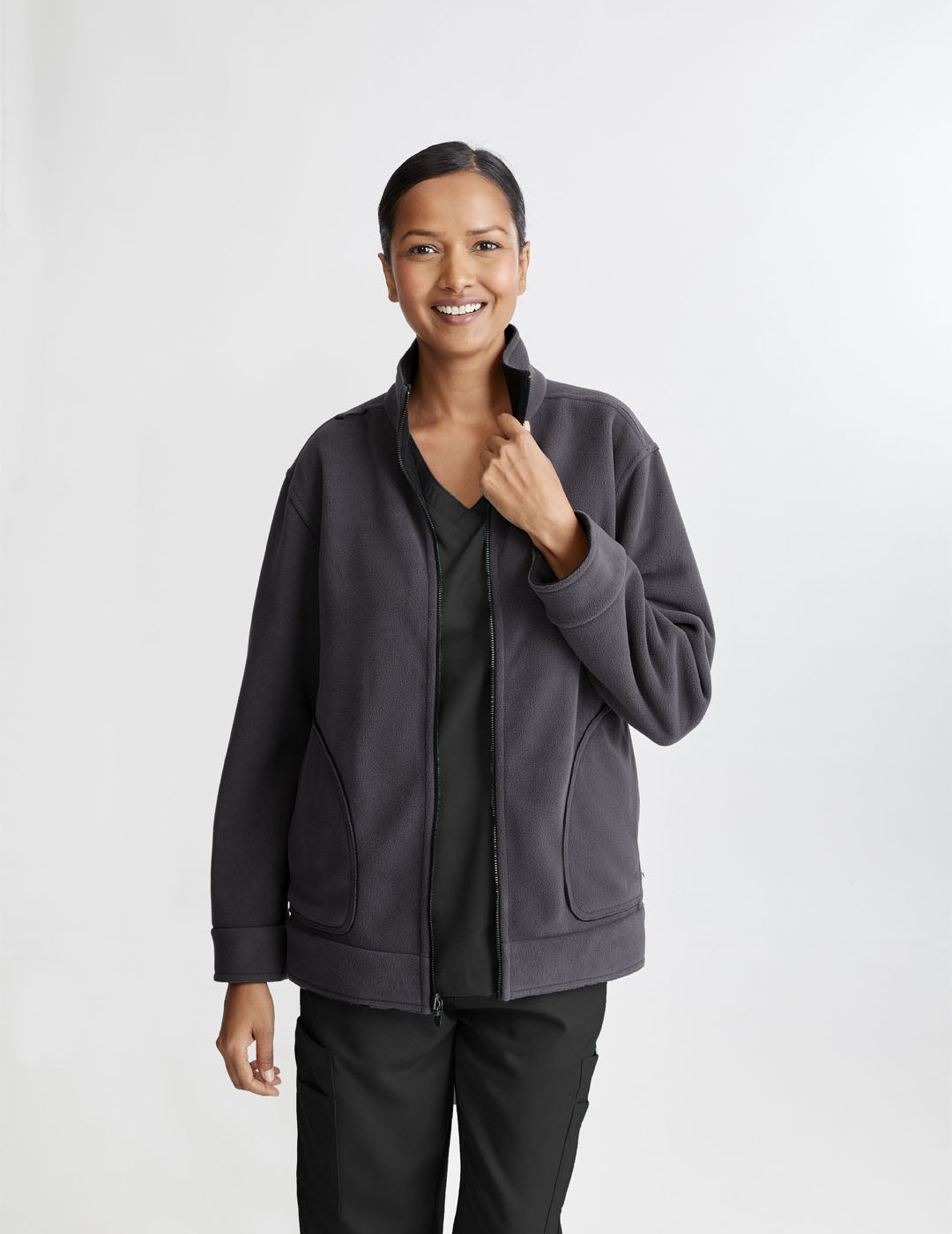 Care+Wear Women's Fleece Jacket in Black/Gray, offering warmth and comfort with a stylish two-tone design for healthcare workers. Model is wearing size Medium