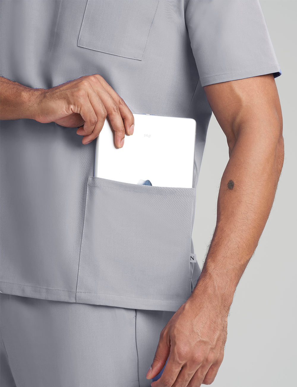 Stone gray men's V-neck scrub top with three pockets, offering comfort and a professional look