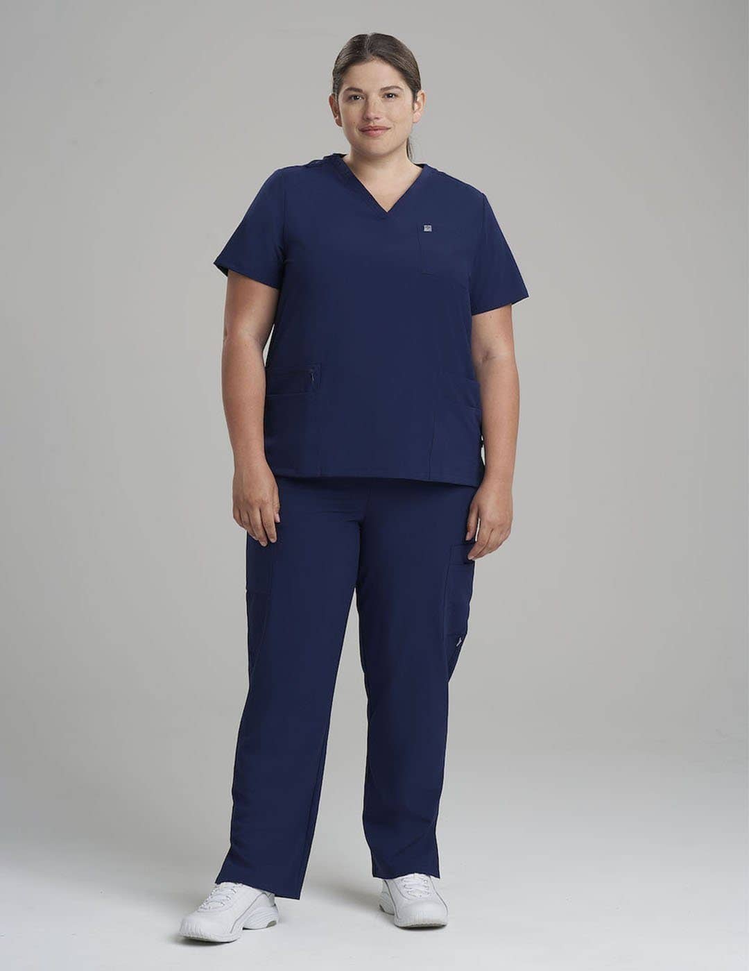 Versatile royal blue V-neck scrub top for women, offering both style and practical utility. Model is wearing size Large