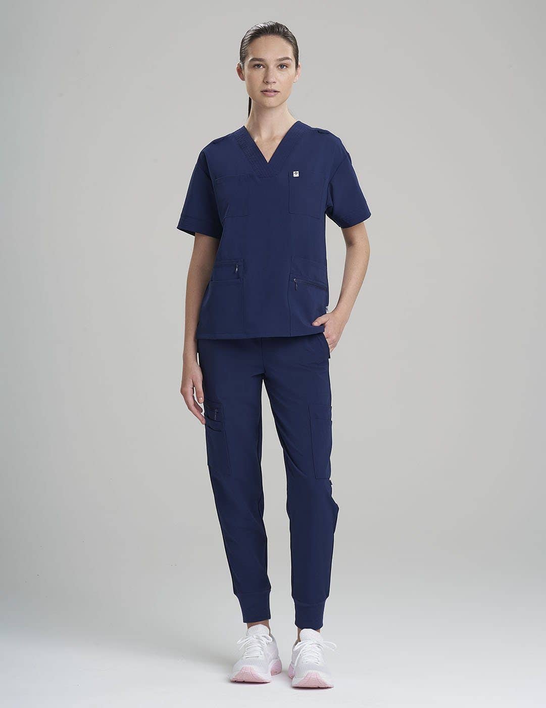 Professional royal blue women's scrub top, offering eight pockets for efficient organization.