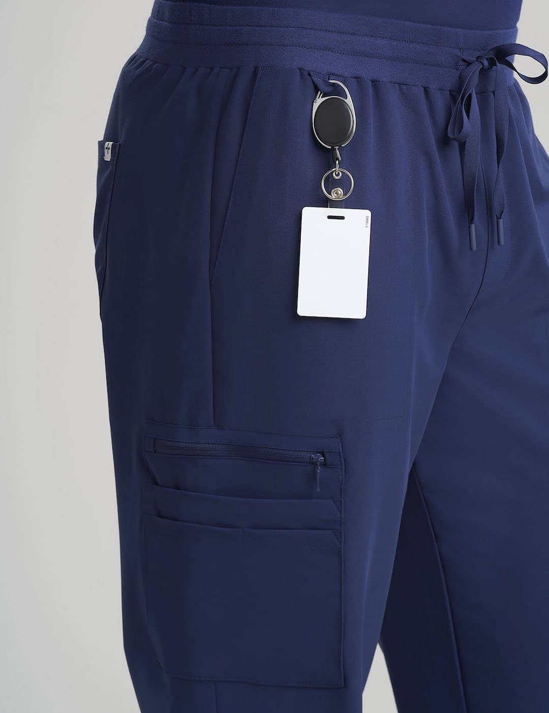 Navy Men's 10-Pocket Jogger Scrub Pants by Care+Wear, blending a comfortable jogger style with multiple pockets for medical essentials. Model is wearing size Large