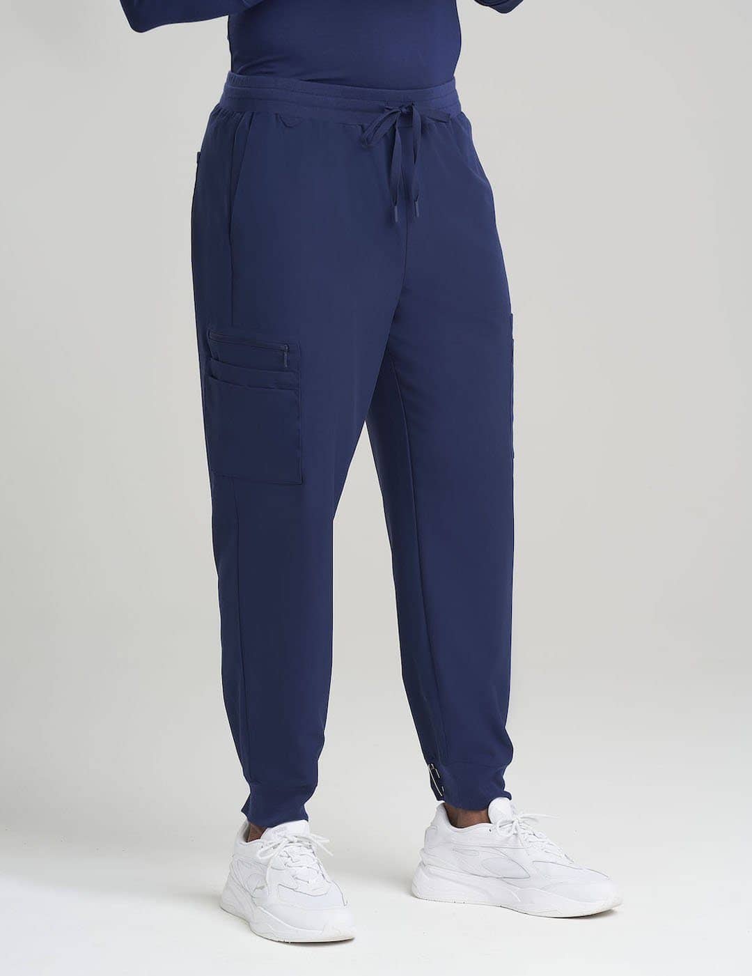 Navy Men's 10-Pocket Jogger Scrub Pants by Care+Wear, blending a comfortable jogger style with multiple pockets for medical essentials. Model is wearing size Large