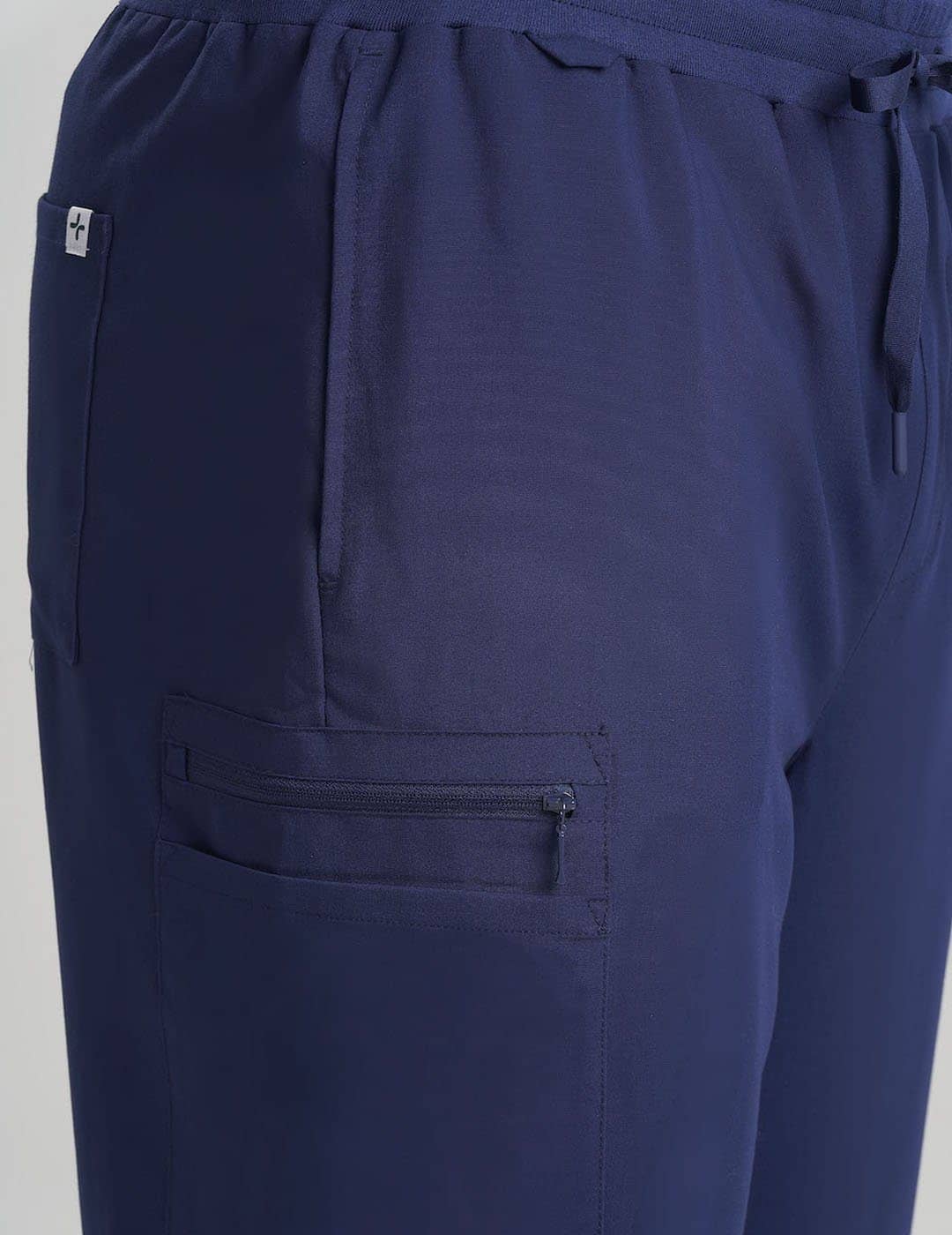 Care+Wear Men's 7-Pocket Straight Leg Scrub Pants in Navy, offering a professional look with multiple storage pockets for healthcare supplies. Model is wearing size Large