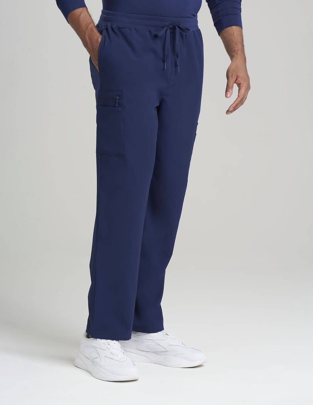 Care+Wear Men's 7-Pocket Straight Leg Scrub Pants in Navy, offering a professional look with multiple storage pockets for healthcare supplies. Model is wearing size Large