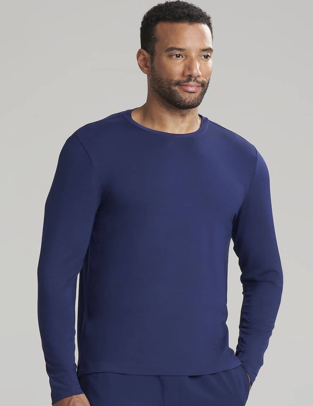 Classic Navy Men's Long Sleeve Underscrub Shirt by Care+Wear, designed for comfort and longevity in healthcare settings. Model is wearing size Large