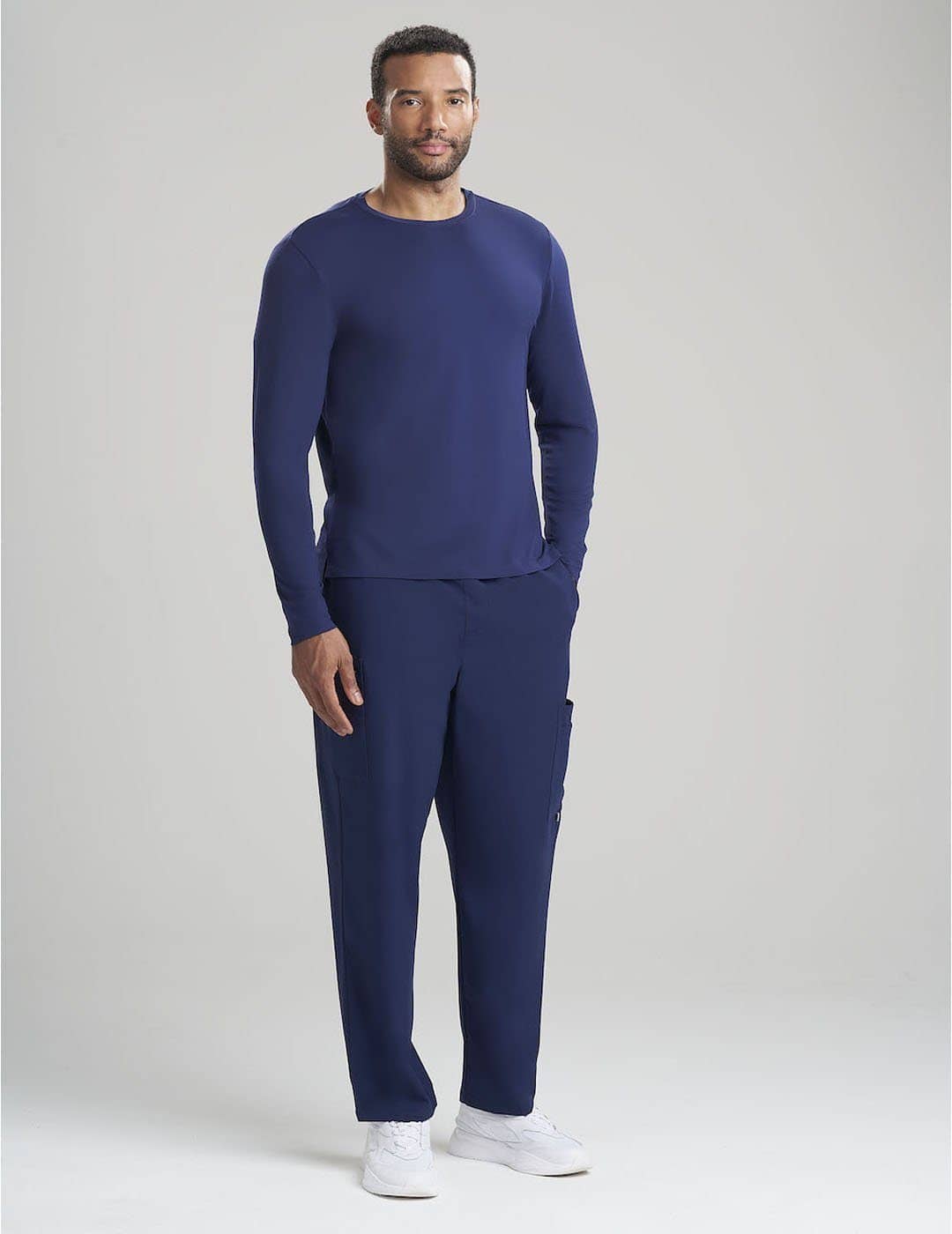 Classic Navy Men's Long Sleeve Underscrub Shirt by Care+Wear, designed for comfort and longevity in healthcare settings. Model is wearing size Large