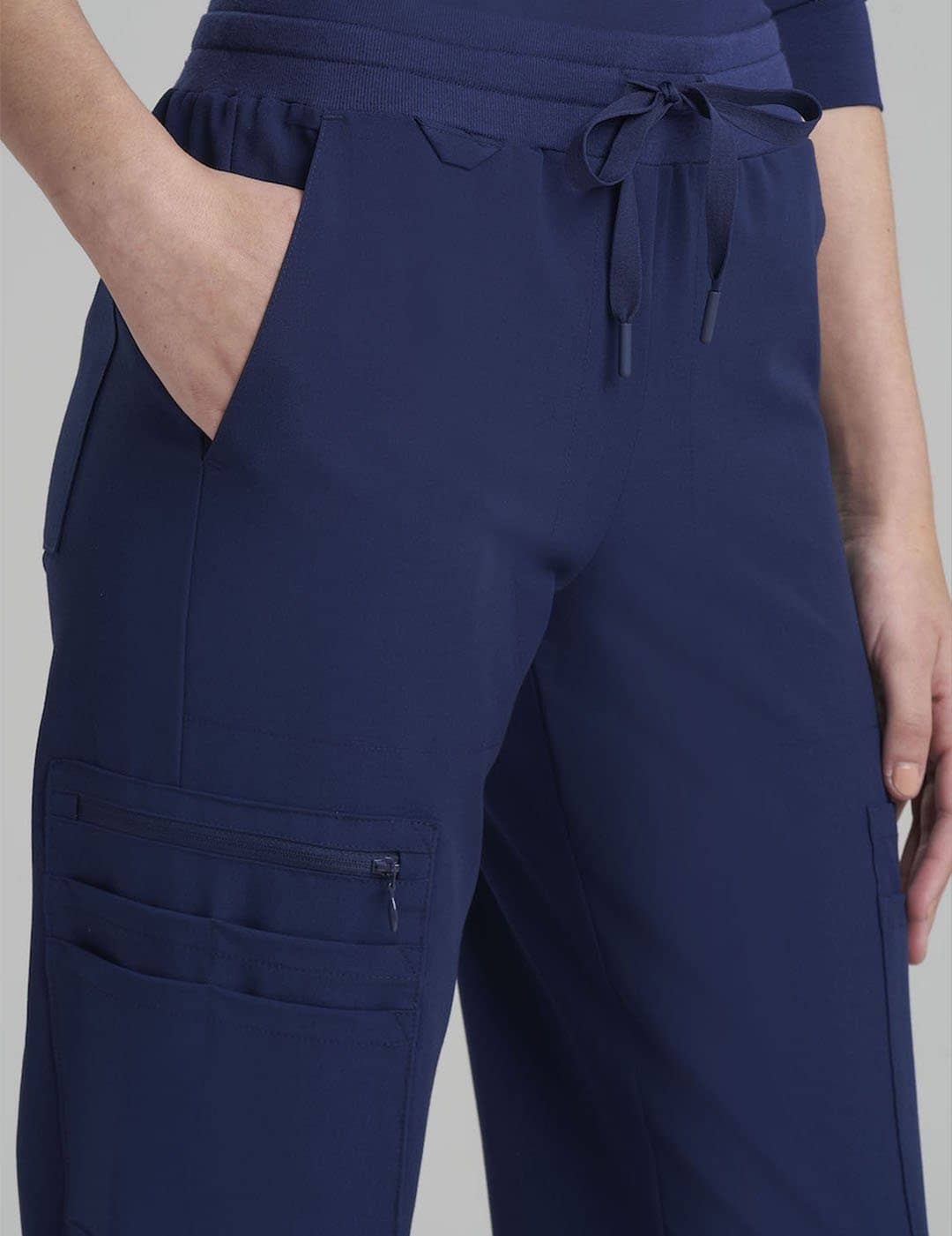 Navy Women's 12-Pocket Scrub Jogger Pants by Care+Wear, providing durable fabric and multiple pockets for practical use. Model is wearing size X-Small