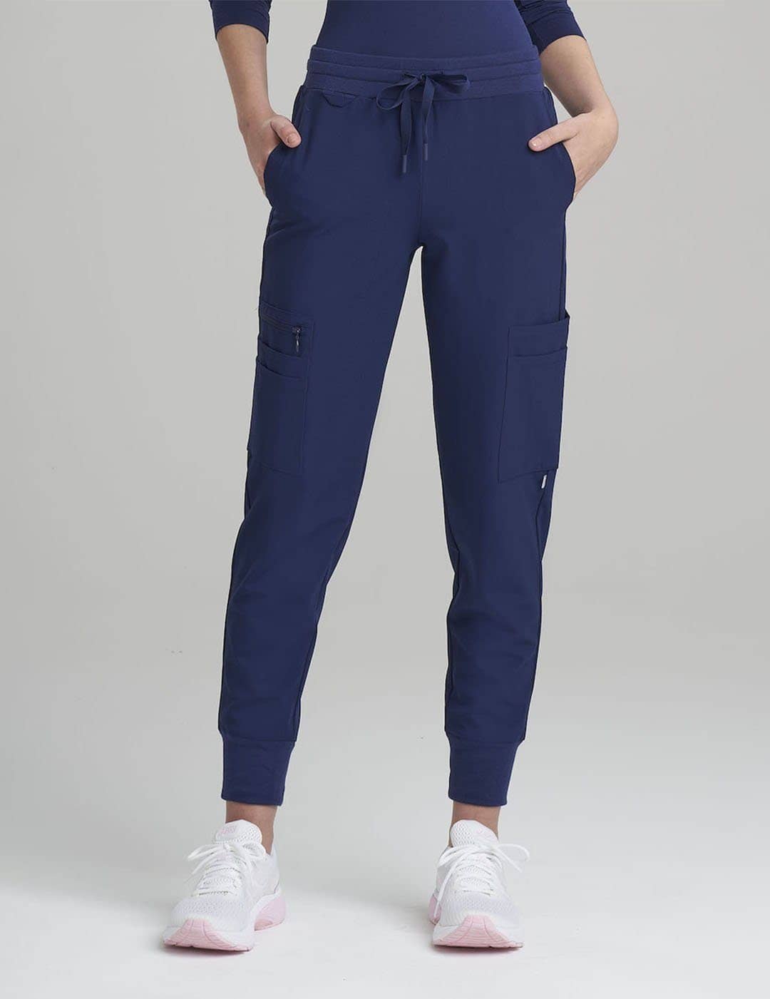 Navy Women's 12-Pocket Scrub Jogger Pants by Care+Wear, providing durable fabric and multiple pockets for practical use. Model is wearing size X-Small