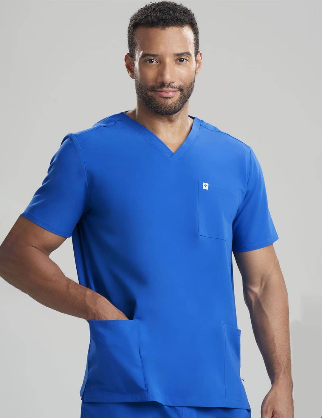 Care+Wear Men's 3-Pocket V-Neck Scrub Top in Royal Blue, featuring a bold color and multiple pockets for convenience during long shifts. Model is wearing size Large