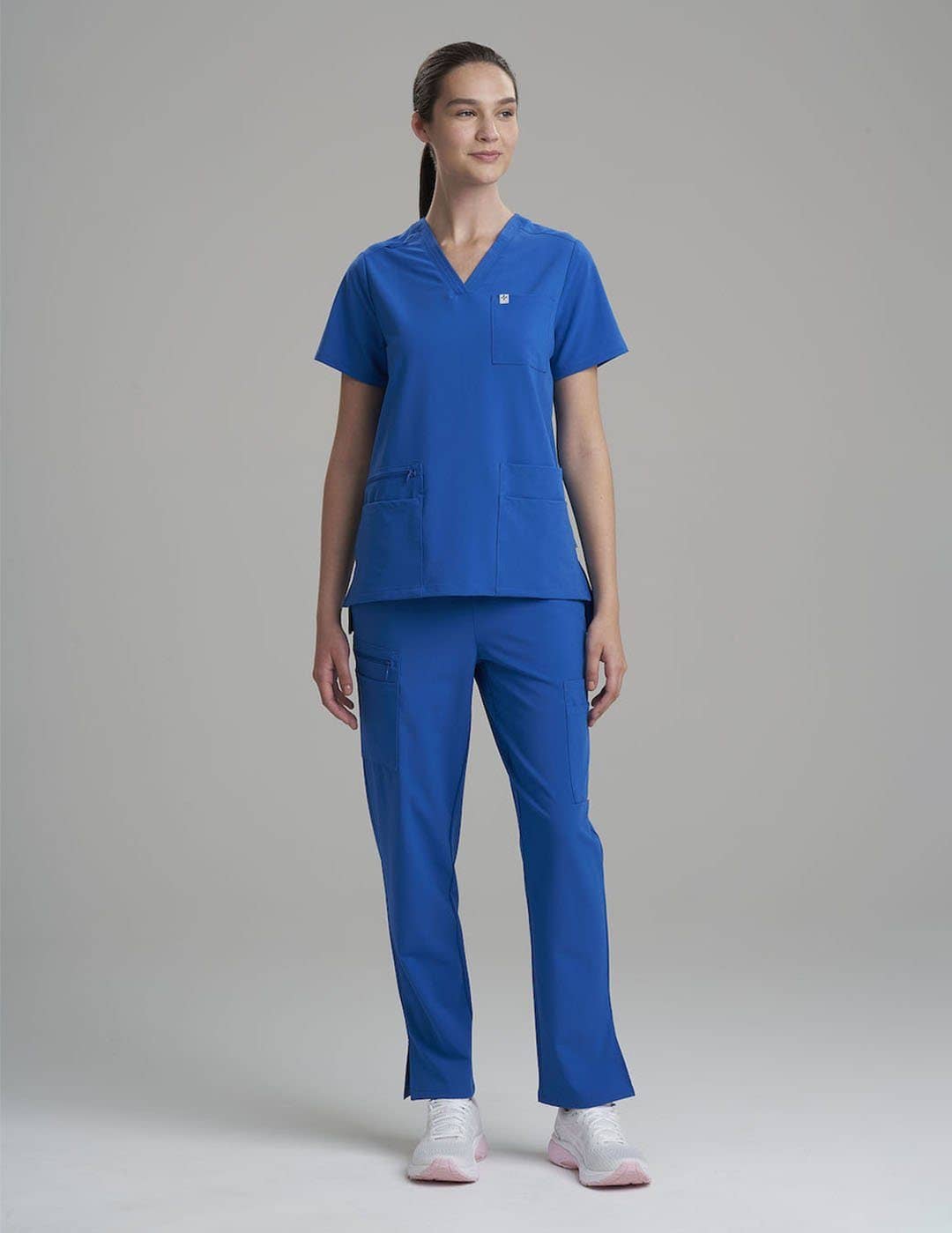 Modern ceil-colored women's scrub top, combining a professional V-neck with six spacious pockets.