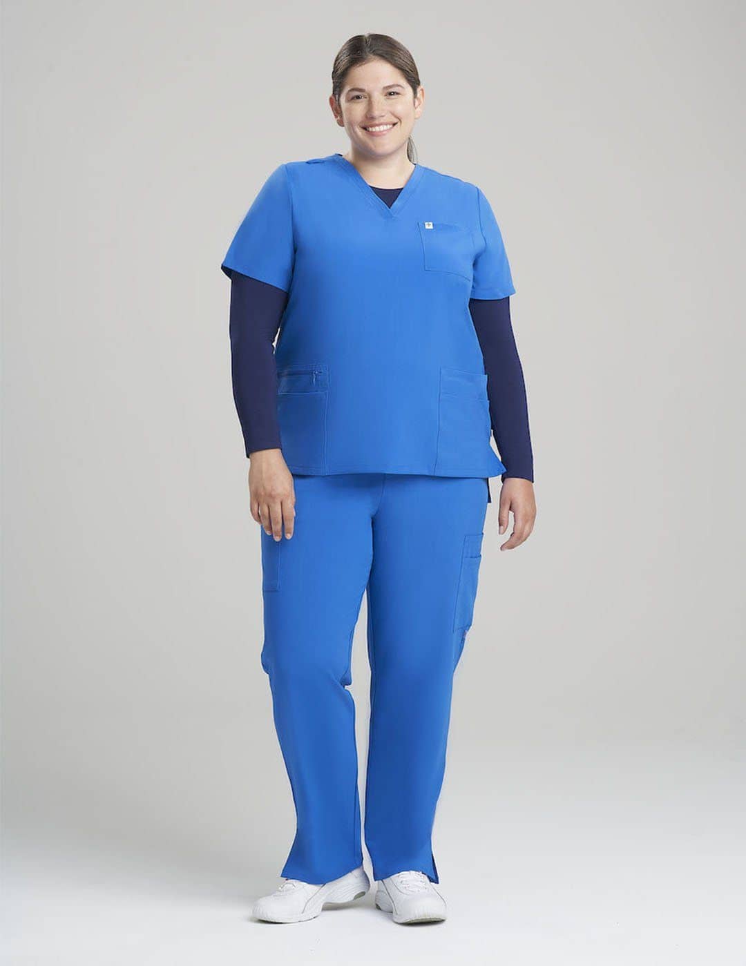 Durable and stylish ceil V-neck scrub top for women, equipped with six pockets for efficiency. Model is wearing size Large