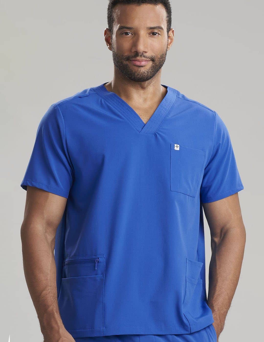 Care+Wear Men's 7-Pocket V-Neck Scrub Top in Royal Blue, combining vibrant color with practical design for healthcare professionals. Model is wearing size Large