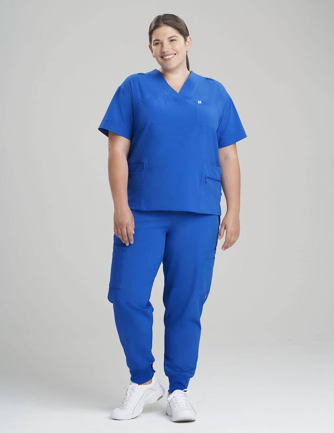 Women's 8-pocket V-neck scrub top in navy, combining professional style with ample storage for medical essentials. Model is wearing size Large