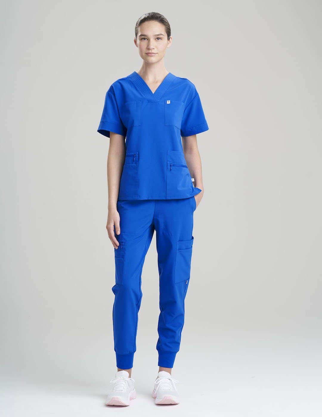Women's 8-pocket royal blue scrub top, combining bold style with practical storage solutions.