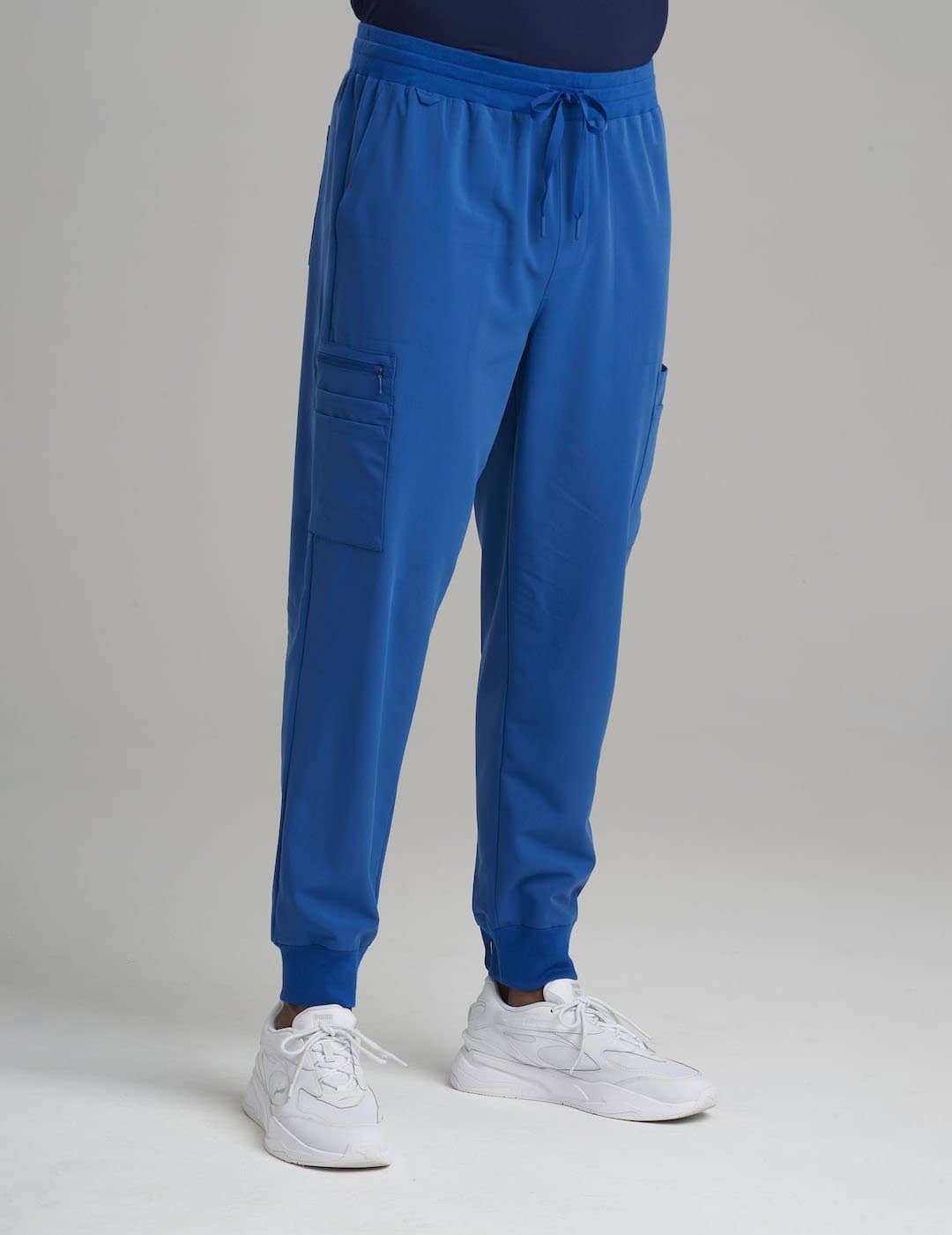 Care+Wear Men's 10-Pocket Jogger Scrub Pants in Royal Blue, offering vibrant style and plenty of storage for healthcare professionals. Model is wearing size Large