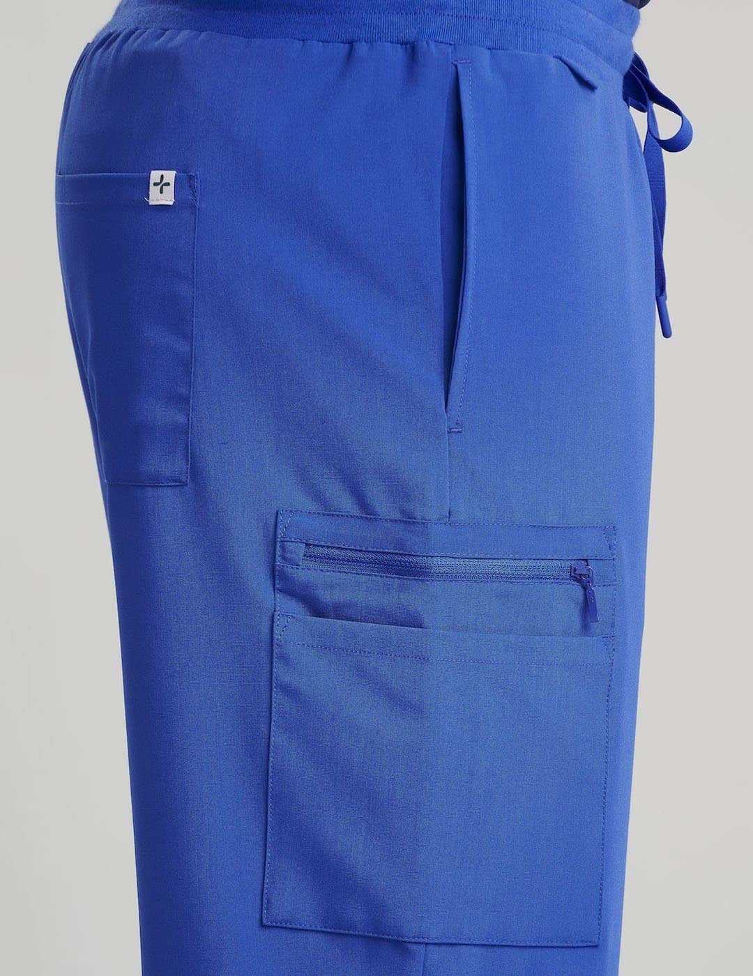 Royal Blue Men's 7-Pocket Straight Leg Scrub Pants from Care+Wear, featuring bold color and functional storage for medical gear. Model is wearing size Large