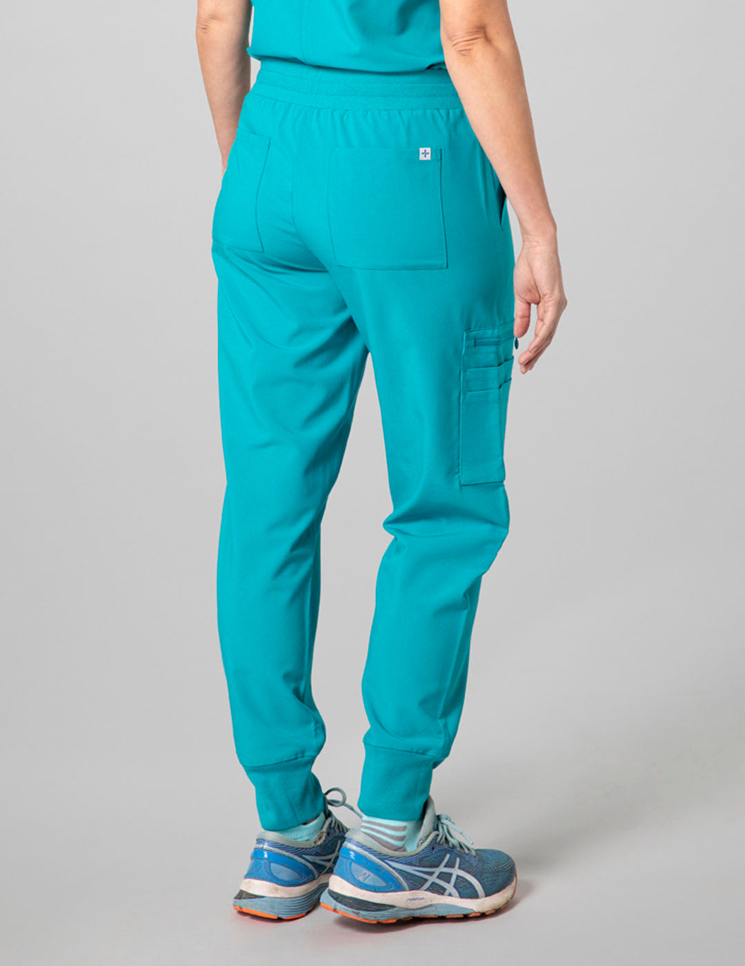 Functional teal jogger scrub pants for women, featuring multiple pockets and a sleek design