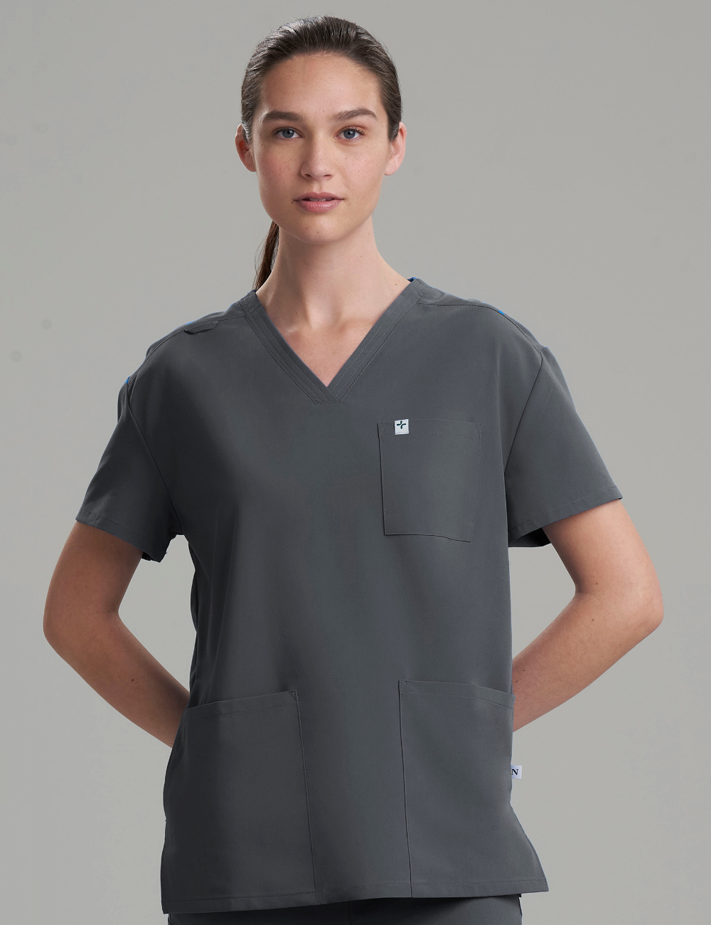 Women's 3-pocket V-neck scrub top in stone gray, offering a sleek and professional design for healthcare.
