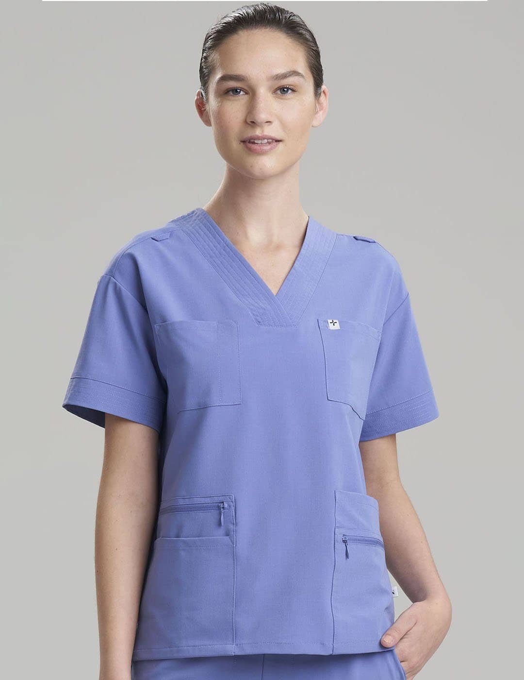 Women's 8-pocket V-neck scrub top in ceil, offering professional style and ample storage. Model is wearing size X-Small