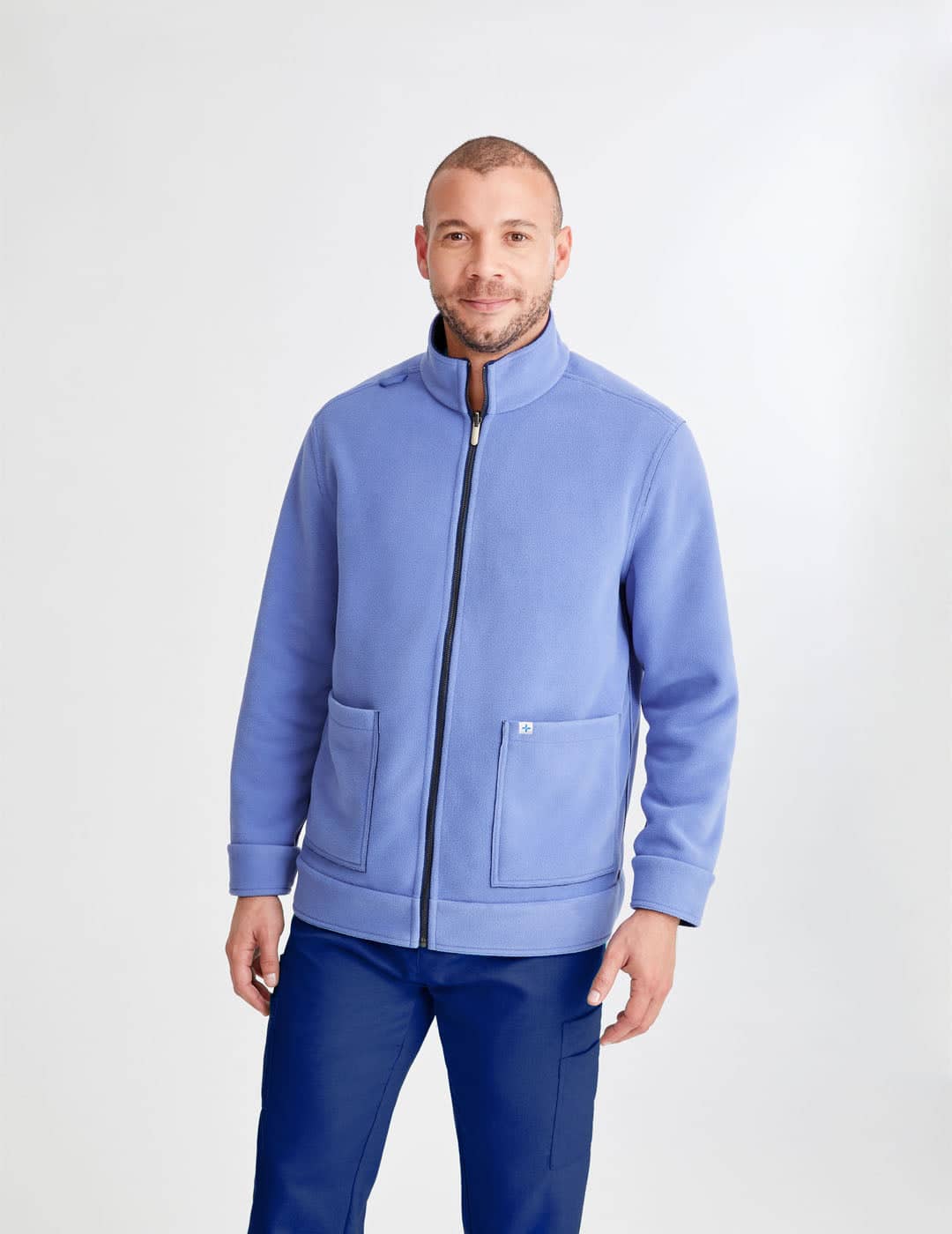 Men's reversible fleece jacket in black and gray, offering dual-color versatility and warmth for healthcare settings. Model is wearing size Large