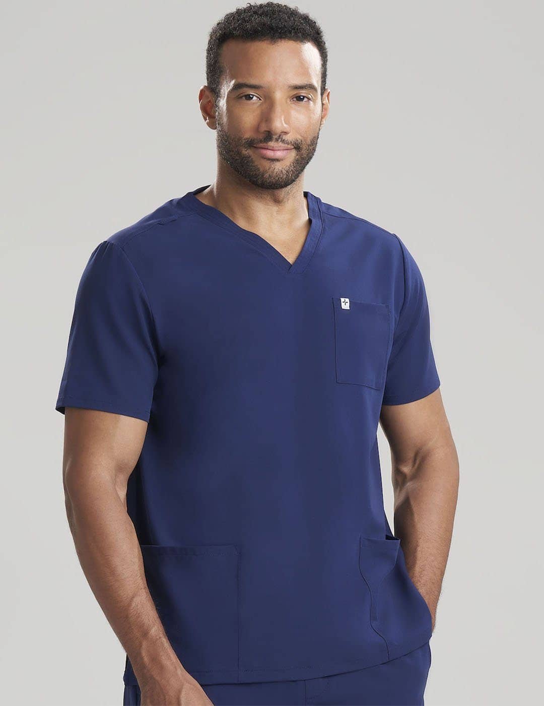 Men&#39;s V-neck scrub top in navy, offering a classic appearance with durable comfort for medical environments